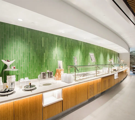 A restaurant with green walls and wooden cabinets.